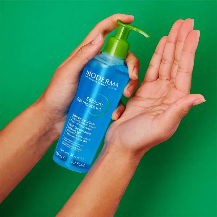 Bioderma bottle being held with a green background